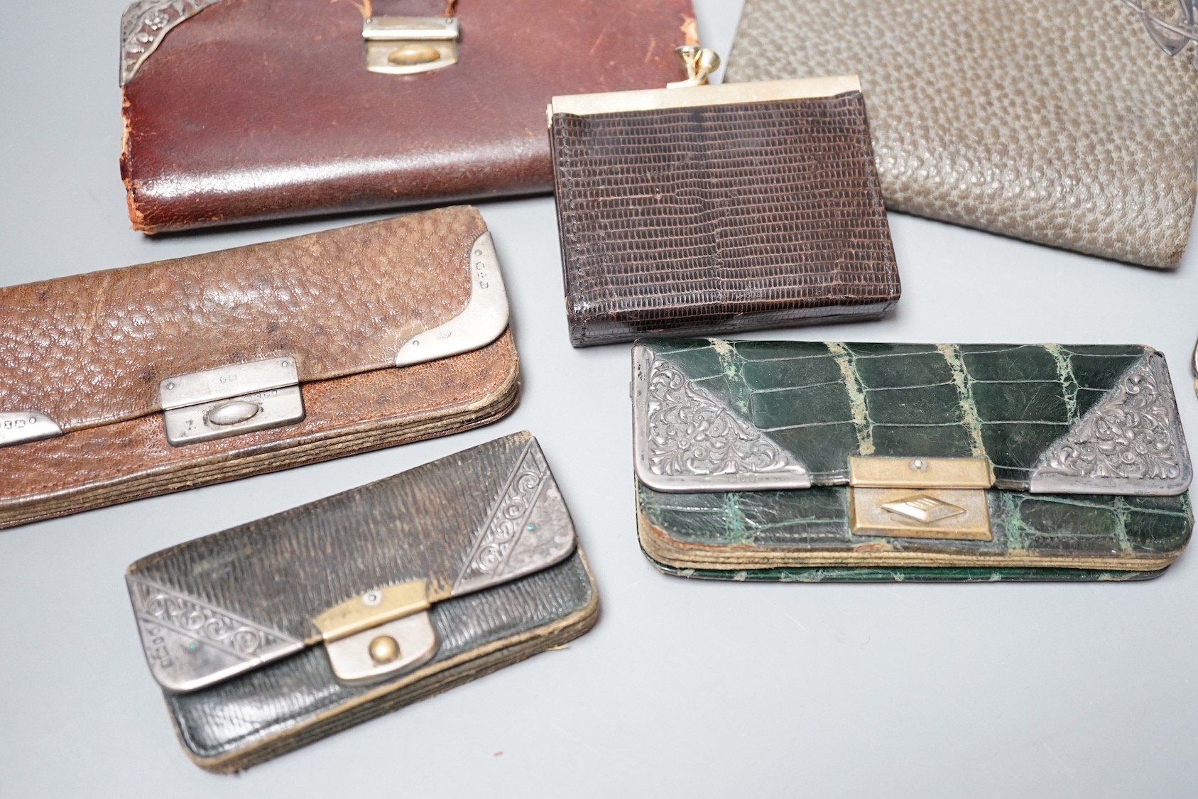 Five assorted early 20th century silver mounted leather purses including Art Nouveau, a similar notebook and one other purse.